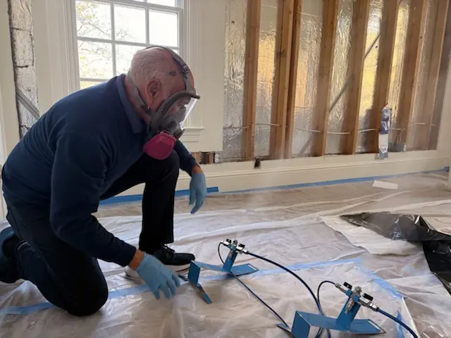 A restoration technician setting drying equipment in a Charleston home stripped to the studs