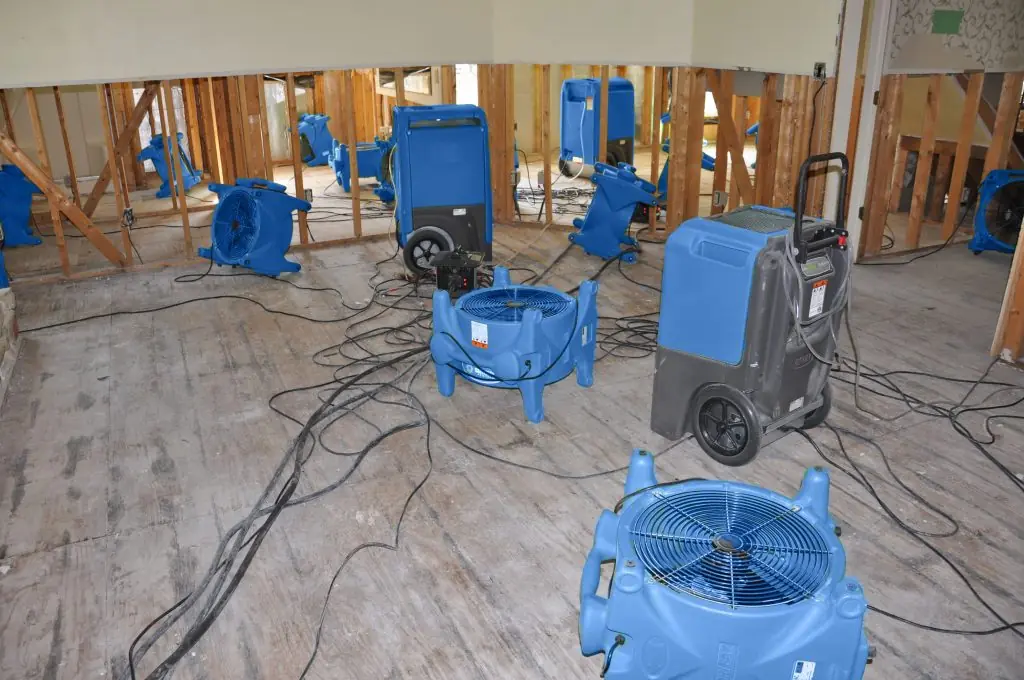 Air movers drying a gutted Charleston room after major water damage